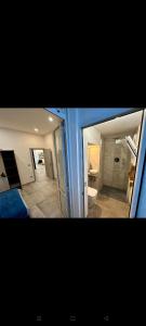 Duas fotografias de uma casa de banho com um WC e um espelho. em Koman House em Savona