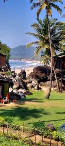 a beach with a palm tree and a house at Ourem Palace in Palolem