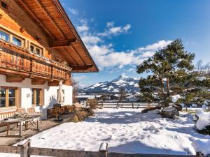 a snow covered patio with a mountain in the background at Chalet-Apartment Lavendel am Lift in Kitzbühel