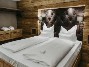 um quarto com uma cama grande e lençóis brancos em Chalet-Apartment Lavendel am Lift em Kirchberg in Tirol