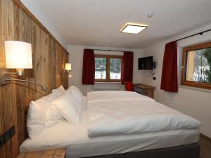 a bedroom with a large bed with white sheets at Apart Loisa in Pettneu am Arlberg