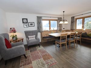 jadalnia i salon ze stołem i krzesłami w obiekcie Apart Loisa w mieście Pettneu am Arlberg