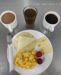 a plate of food with cheese and crackers and coffee at Hotel Bicentenario Rionegro in Rionegro