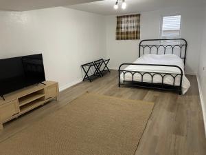 Schlafzimmer mit einem Bett und einem Flachbild-TV in der Unterkunft Mustang House in Sioux City