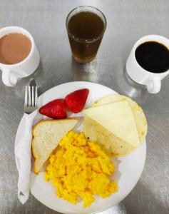 un plato de huevos y tostadas con fresas y café en Hotel Bicentenario Rionegro, en Rionegro