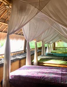 a bedroom with a bed with a canopy at Captain Coconuts Gili Air in Gili Air