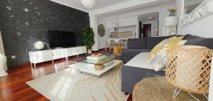 ein Wohnzimmer mit einem blauen Sofa und einem TV in der Unterkunft El Centro de Vigo in Vigo