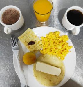 a plate of food with eggs and cheese and coffee at Hotel Bicentenario Rionegro in Rionegro