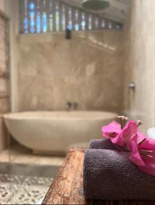 - Toalla con arco rosa en una mesa del baño en Captain Coconuts Gili Air en Gili Air