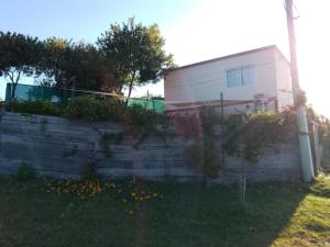 una casa con una pared de retención junto a un edificio en IDALIA, en Barra del Chuy