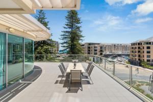 a balcony with a table and chairs on a building at Belle Escapes - Sea the Views in Glenelg