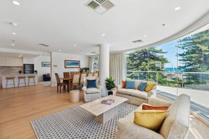 a living room with a couch and a table at Belle Escapes - Sea the Views in Glenelg