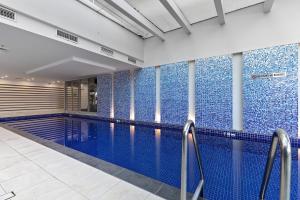a swimming pool with blue tiles on the walls at Belle Escapes - Sea the Views in Glenelg