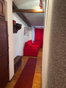a living room with a red couch and red curtains at Grazioso monolocale in Borgata Sestriere
