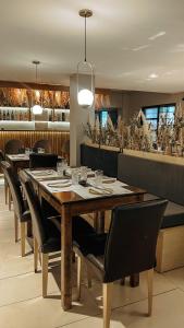 uma sala de jantar com uma mesa de madeira e cadeiras pretas em Hospedaje Los Ilustres em Tunuyán