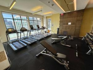 einen Fitnessraum mit einer Reihe von Laufbändern und Stühlen in der Unterkunft Stylish Suite at 300 Front Street W in Toronto