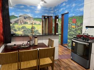 eine Küche mit einem großen Gemälde an der Wand in der Unterkunft Casa Do Guh in São Thomé das Letras + 14 Fotos