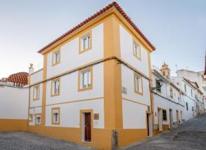 埃爾瓦什的住宿－Azinheira Suites Townhouse - Alojamento Turístico，街道上的黄色和白色建筑