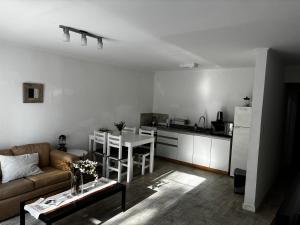 a living room with a couch and a table and a kitchen at Al Río in San Antonio de Areco