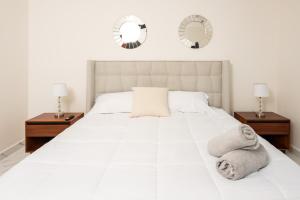 um quarto com uma grande cama branca e 2 espelhos em 2BR Moderno en residencial Ombu em Cancún