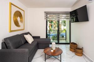 sala de estar con sofá y mesa en 2BR Moderno en residencial Ombu, en Cancún