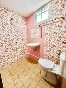 a pink bathroom with a toilet and a sink at No.9 Bang Khun Non in Bangkok Noi