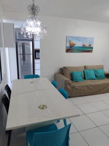 a living room with a white table and a couch at Lindo Flat espaçoso em Muro Alto região de Porto de Galinhas com vista total para as piscinas in Ipojuca