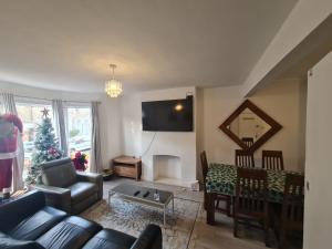 a living room with a couch and a christmas tree at 3-Bed House in London self-contained in Ladywell in London