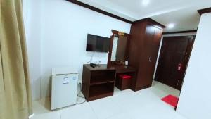 ein kleines Zimmer mit Kühlschrank und Fernseher in der Unterkunft 水果天堂旅馆Fruit Paradise in Patong Beach