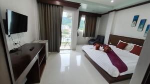 ein Schlafzimmer mit einem Bett mit zwei Teddybären darauf in der Unterkunft 水果天堂旅馆Fruit Paradise in Patong Beach