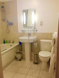 a bathroom with a sink and a toilet and a bath tub at The Waterman's Arms in Totnes