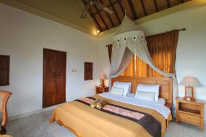 Un dormitorio con una cama con un osito de peluche encima. en Hibiscus Cottages, en Ubud