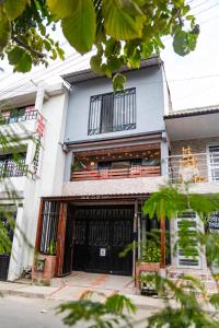 un edificio bianco con porte e finestre nere di Coliving7 Aparta Hotel & Habitaciones a Ibagué