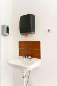 a tv on a wall above a bathroom sink at Suites Apodaca in Monterrey