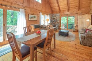 comedor y sala de estar con mesa y sillas en River Retreat Cabin en Arden