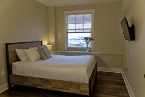 a bedroom with a bed with a television and a window at Hotel Leo in Bellingham