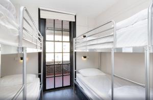 a room with two bunk beds and a window at The Lansdowne Hotel in Sydney