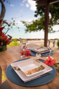 einen Tisch mit einem Teller und Weingläsern darauf in der Unterkunft Matira Beach Raitea 1 in Bora Bora