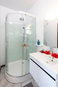 baño blanco con ducha y lavamanos en Matira Beach Raitea 1, en Bora Bora
