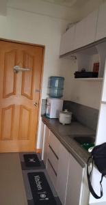 una pequeña cocina con puerta y encimera en CRYSTAL CONDO RENTAL, en Calambá
