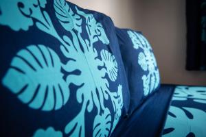 a blue couch with a blue and white blanket at Matira Beach Raitea 1 in Bora Bora