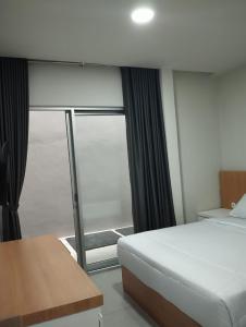 מיטה או מיטות בחדר ב-Djuragan Kamar Gatsu