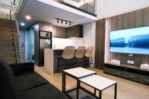 a living room with a couch and a tv at Aster Apartment Bali in Canggu