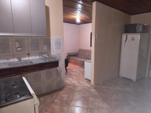 a kitchen with a refrigerator and a couch in it at Casa de Praia Completa em Cabo Frio 04 para até 5 Pessoas in Cabo Frio