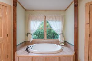 a bath tub in a room with a window at Heaven's Point in Old Fort +44 photos