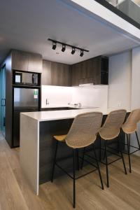 a kitchen with a counter and four chairs in it at Aster Apartment Bali in Canggu
