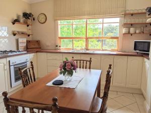 una cucina con tavolo e vaso di fiori di Cottage in Uraidla a Uraidla