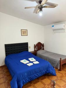 1 dormitorio con 2 camas y ventilador de techo en 4 Ases Hotel en Embalse