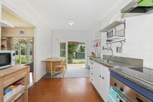 a kitchen with a sink and a table in it at Back of Beyond Cottage in Rotoiti