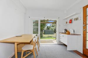 a kitchen and dining room with a wooden table and chairs at Back of Beyond Cottage in Rotoiti